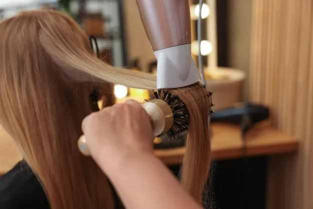 Close-up of keratin treatment being smoothed into straight hair with a brush.