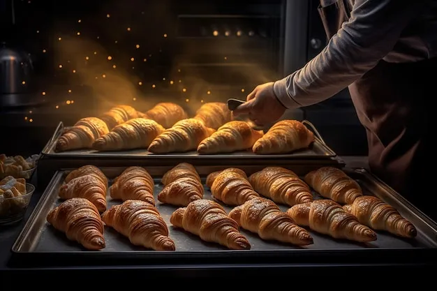 Panaderos trabajando con croissants en el horno de una panadería, mostrando el proceso artesanal.