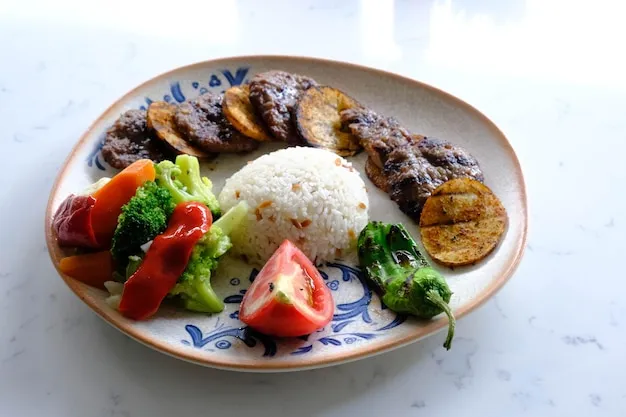 Grilled steak slice alongside rice and beans.