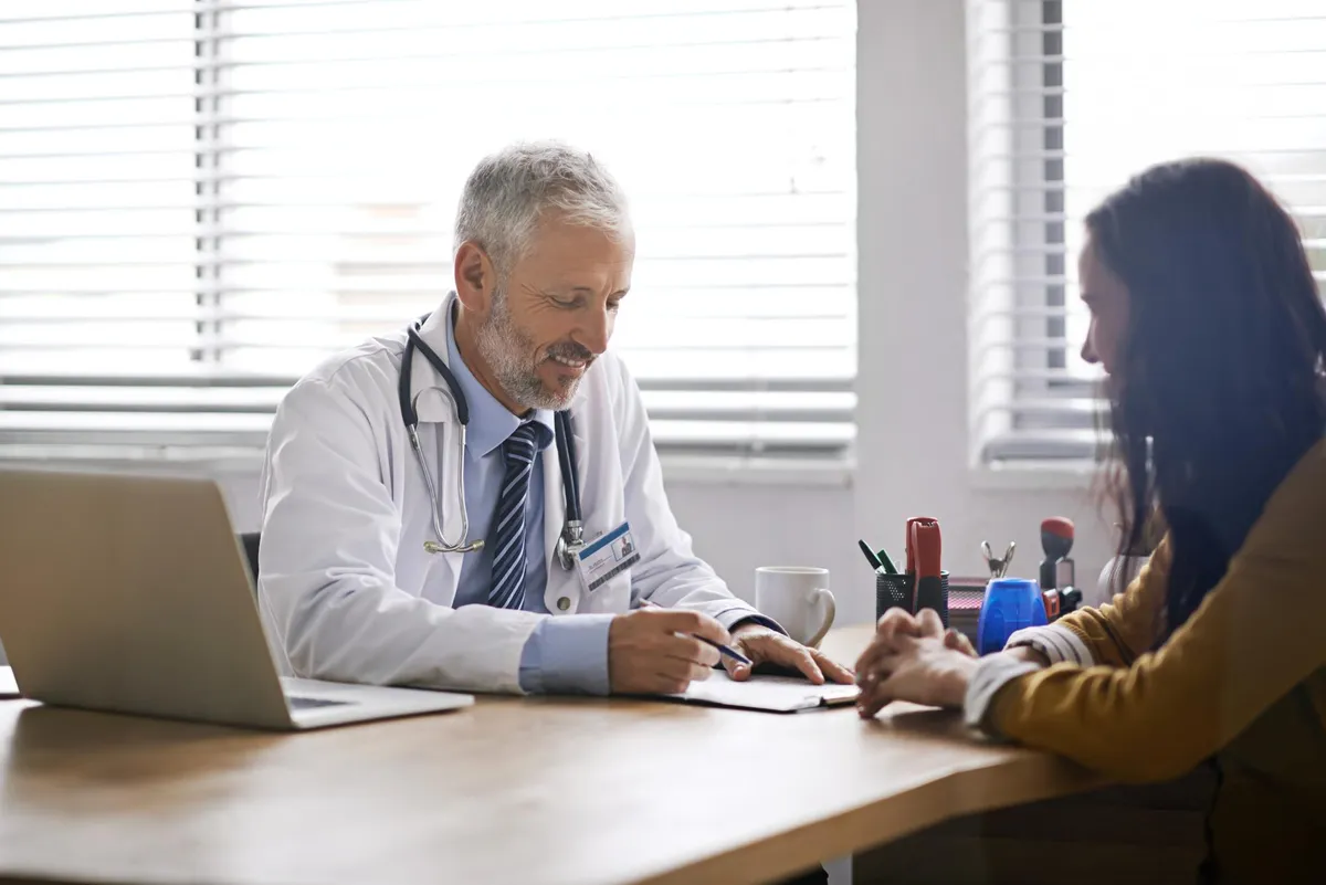 Attorney advising client on medical malpractice claim in a law firm conference room.