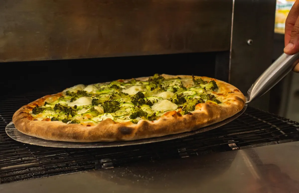 Pizza pequeña recién horneada con ingredientes frescos.