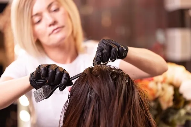 Cabello con mechas claras siendo teñido en salón.