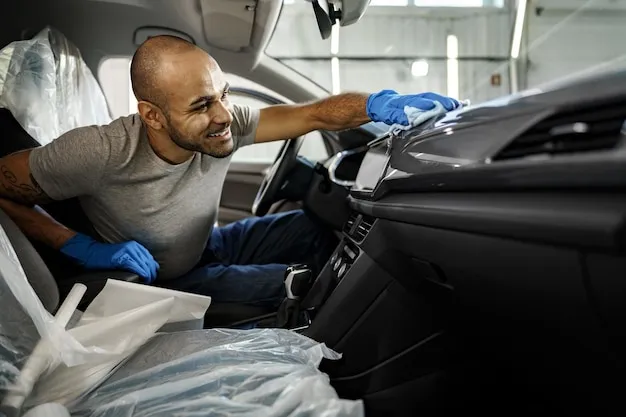 Skilled technician performing detailed car cleaning and polishing inside a vehicle at iDetail Miami.
