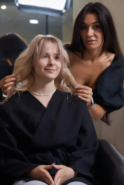 Stylist carefully cutting a woman's hair to create a stylish layered look.