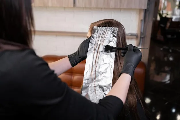 Client with foils in hair during highlighting service in salon.