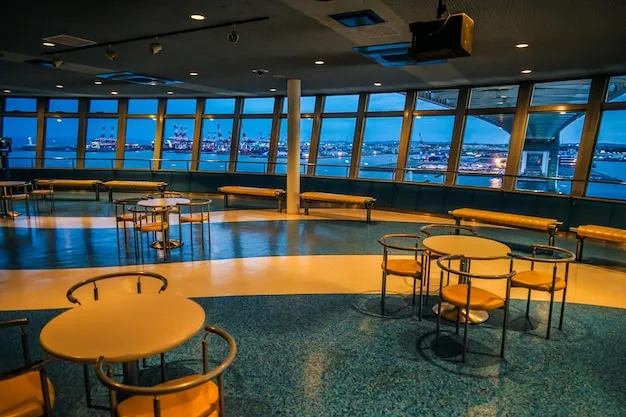 Interior view of a clean, open cruise terminal lobby with counters and signage.