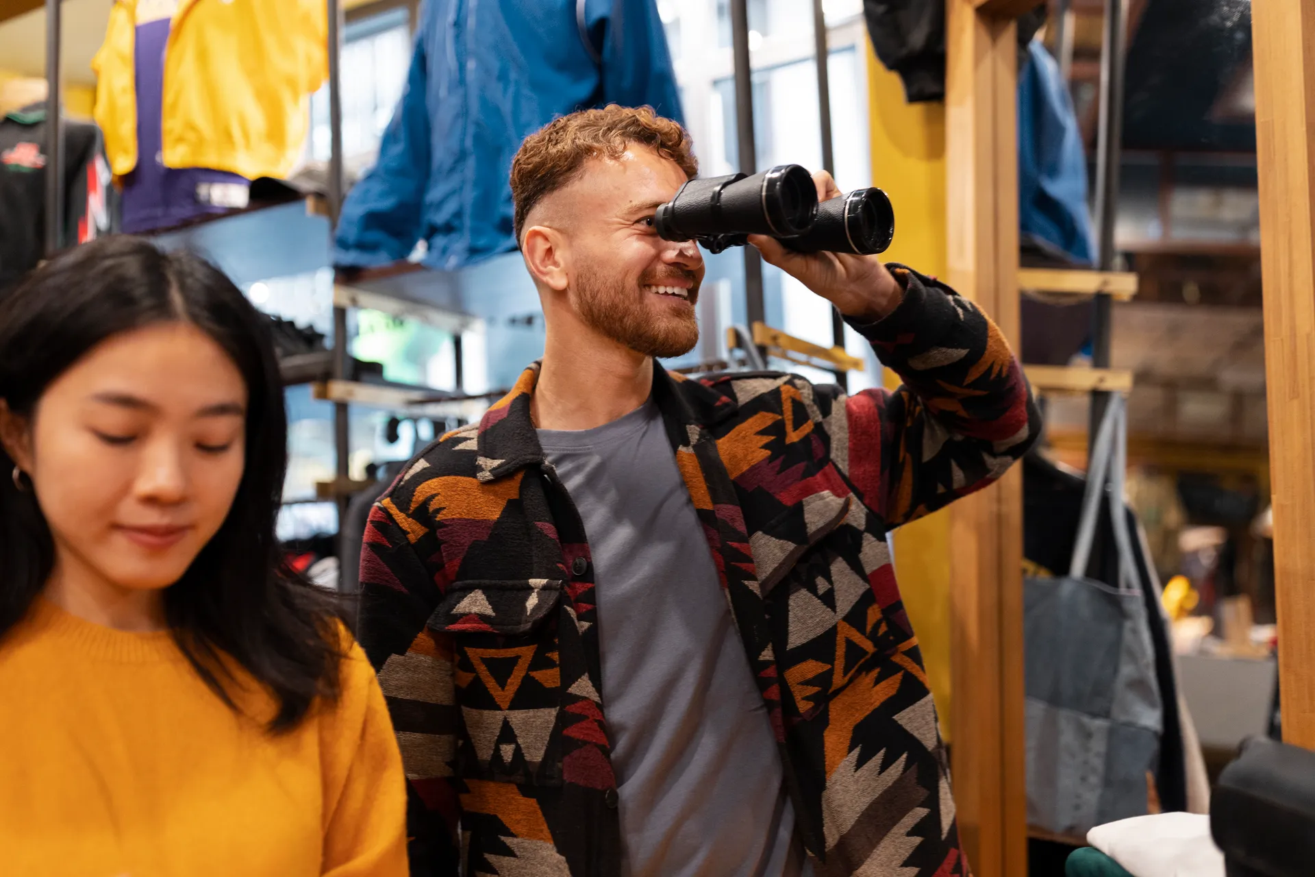 Equipo de NUDE PROJECT atendiendo clientes en la tienda de Fuencarral, Madrid, con prendas streetwear de fondo.