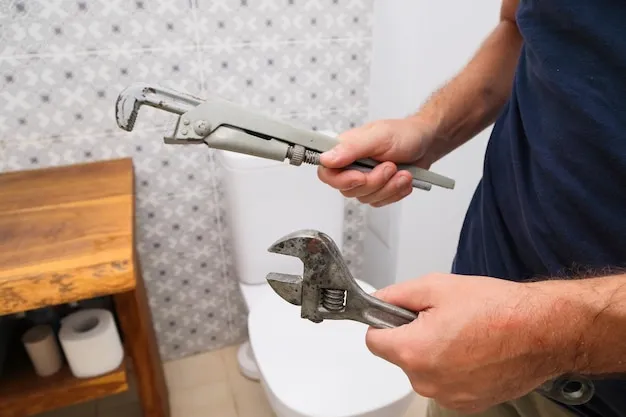 Close-up of plumber tightening fittings on a leaking pipe.