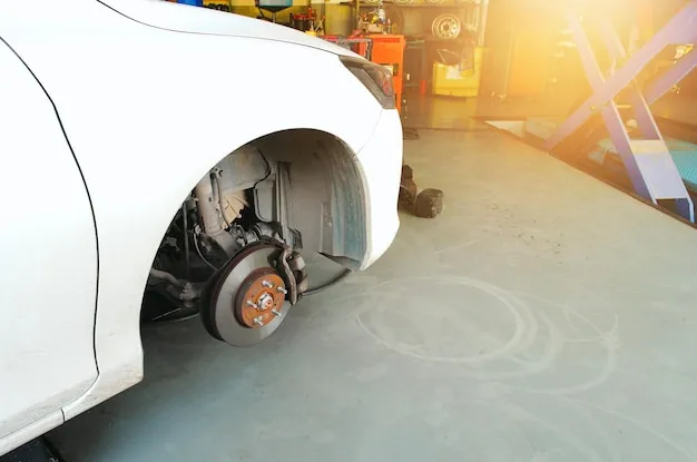 Close-up of mechanic inspecting car brakes with tools.