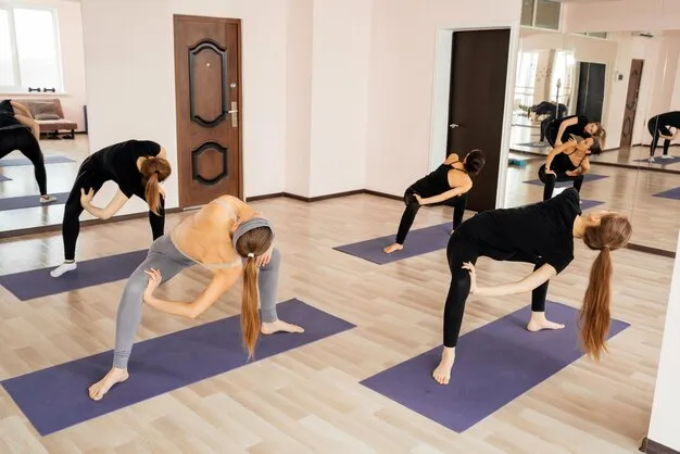 Class engaging in strength-building yoga sculpt exercises.