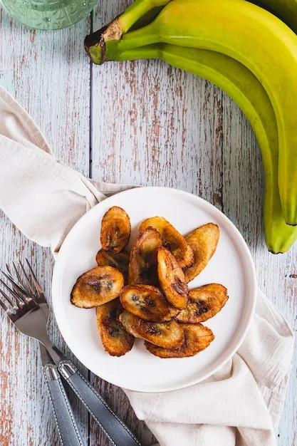 Crispy plantain slices accompanied by beans.