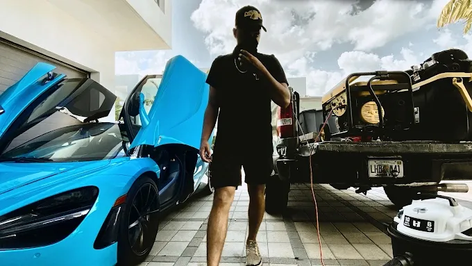 Professional mobile detailing setup featuring a blue McLaren and specialized cleaning equipment in Miami.