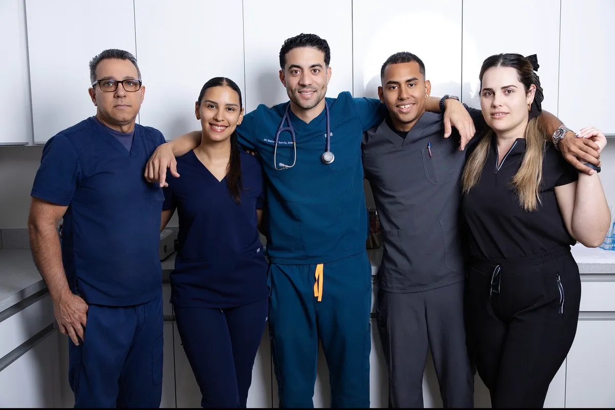 A group photo of the Miller Pets Animal
Hospital team, including Dr. Garcia and Karla Rosario, standing together in
their clinic.