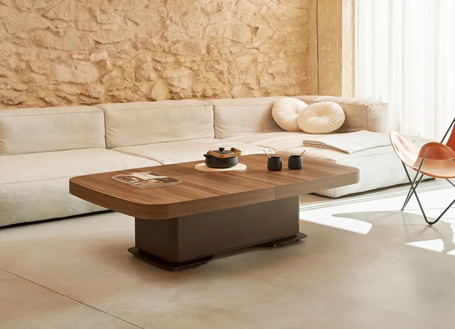 Mesa de centro de nogal con base central frente a un sofá modular, mueble auxiliar en Sgarpa Muebles Torrent