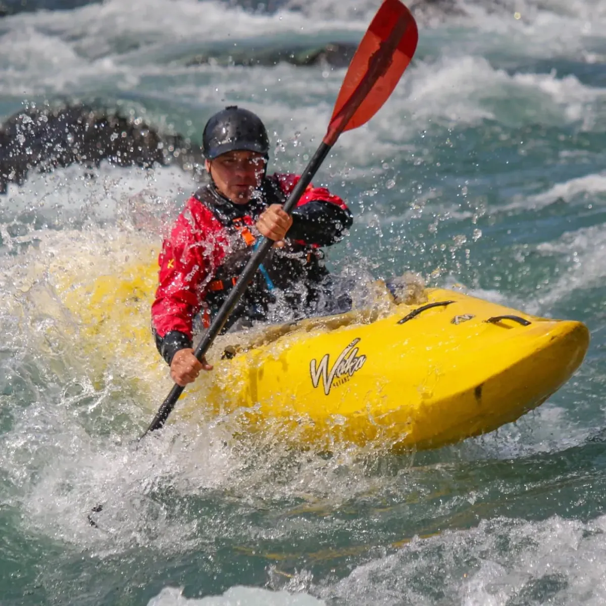 Practicando kayak en un entorno natural rodeado de montañas.