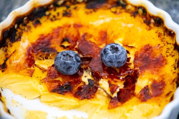 Crème brûlée featuring torched sugar crust and berries.