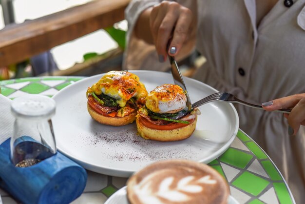 Cafe Bea team members presenting colorful brunch plates to guests in a sunny, welcoming dining space.