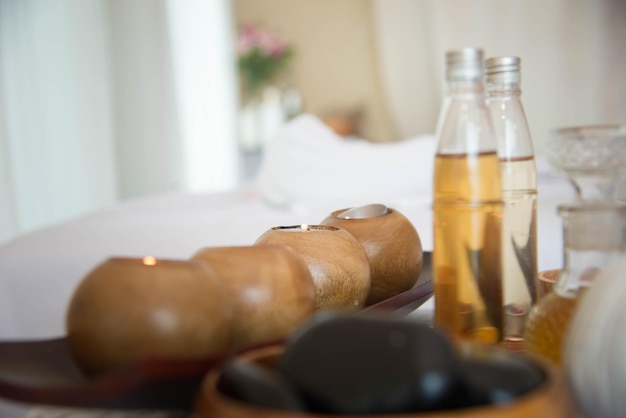 Bottles of essential oils and hands massaging a client's back during aromatherapy session at home.