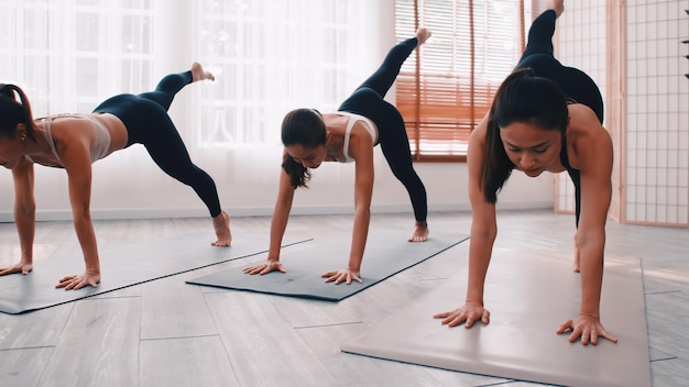 Yogis in warrior poses during a vigorous power yoga session.