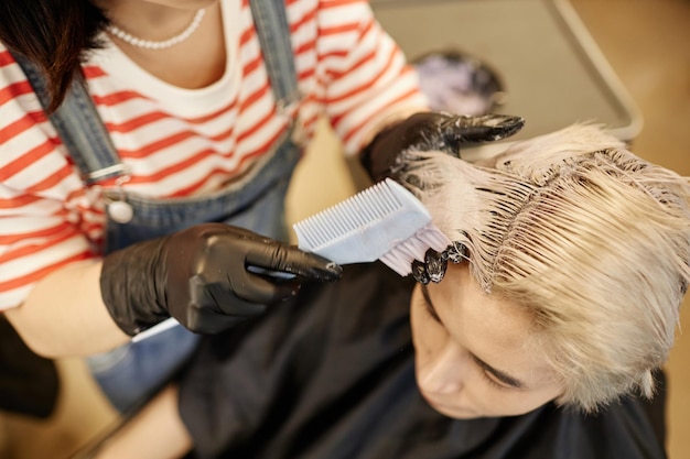 Stylist expertly applying hair color for vibrant, natural highlights.