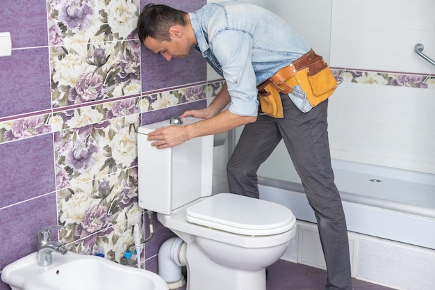 Plumber using plunger on a severely clogged toilet.