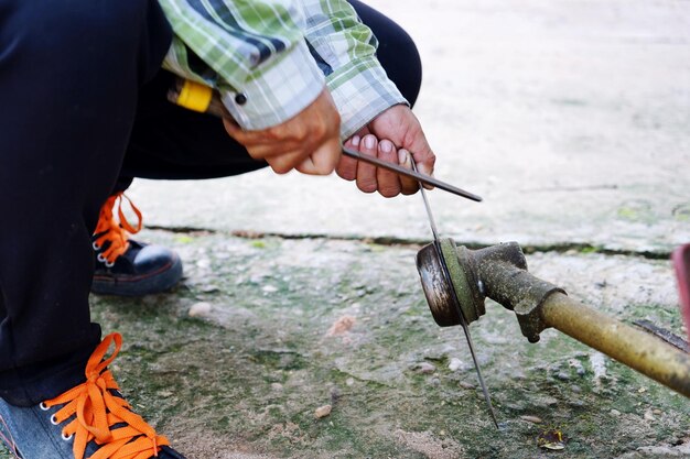 Plumber fixing burst pipe in a wet indoor area.
