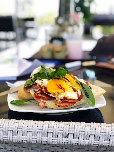 Inviting brunch table setup featuring Eggs Benedict, burrata salad, coffee cups, and warm restaurant ambiance in Miami.