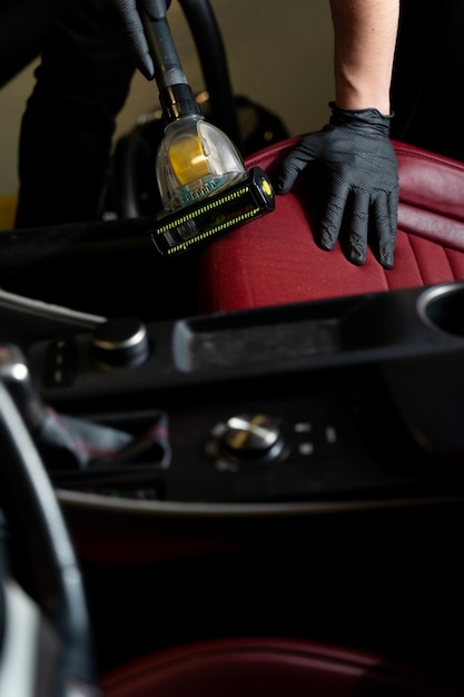 Technician performing full car detailing on exterior and wheels.