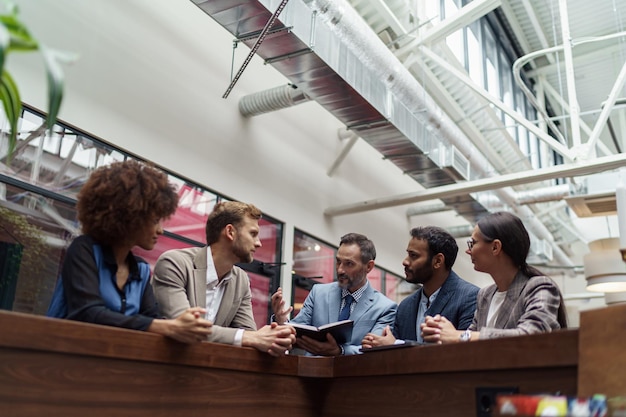 Researchers in professional attire engaging in discussions and networking within a contemporary convention center setting.