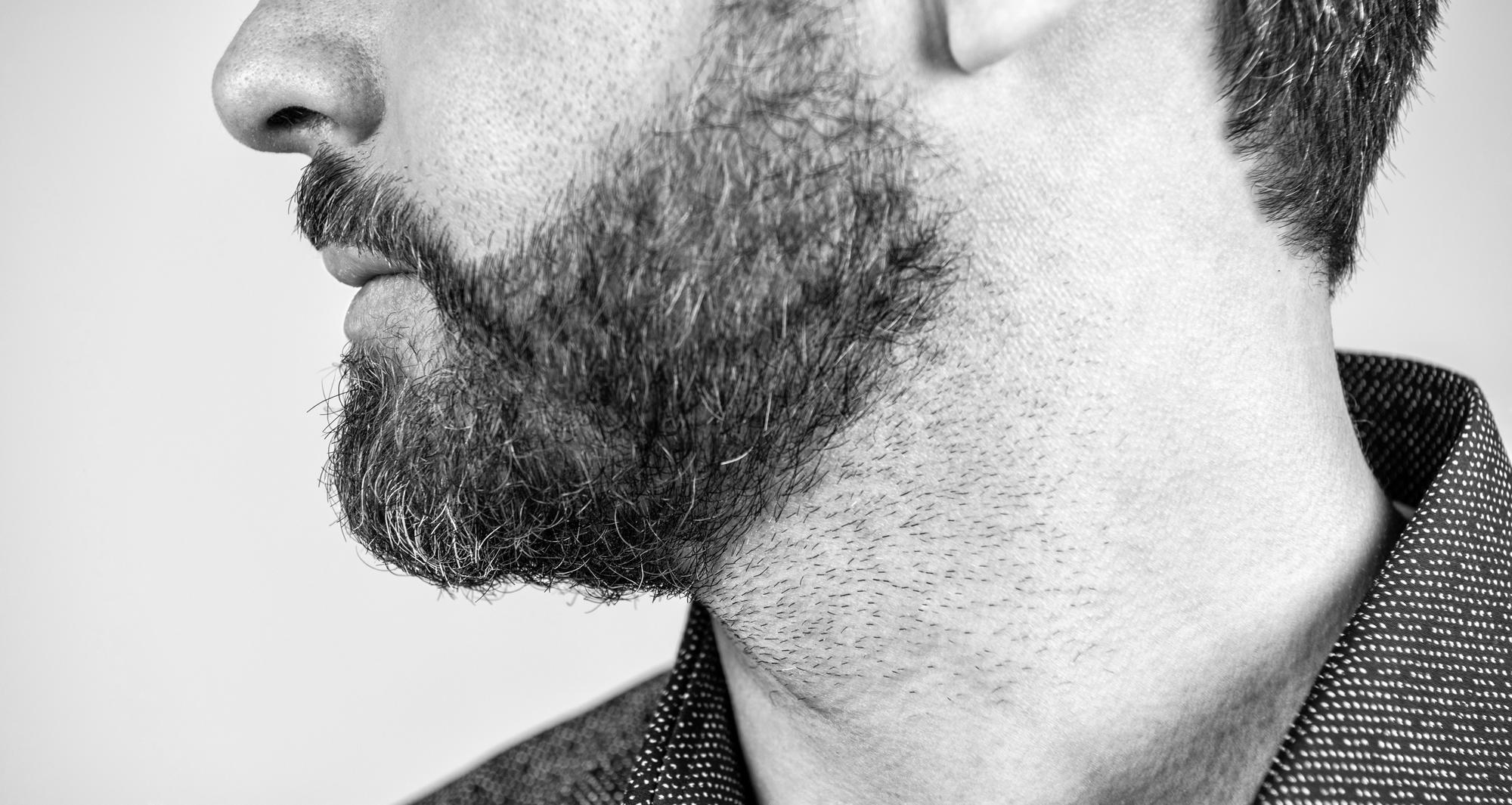 Barber performing precise beard shape-up.