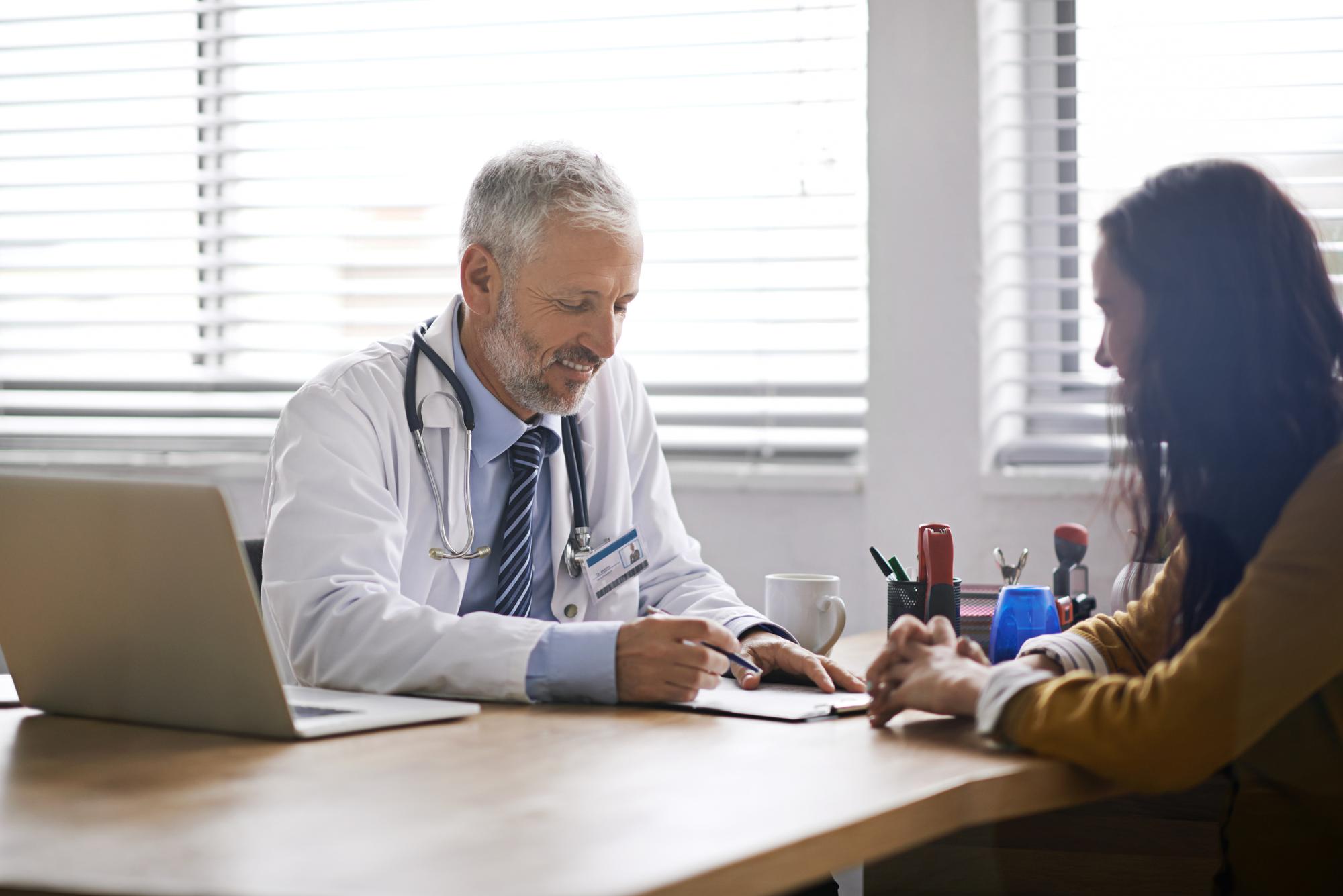 Attorney advising client on medical malpractice claim in a law firm conference room.