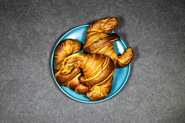 Croissant francés clásico dorado y apetitoso en primer plano.
