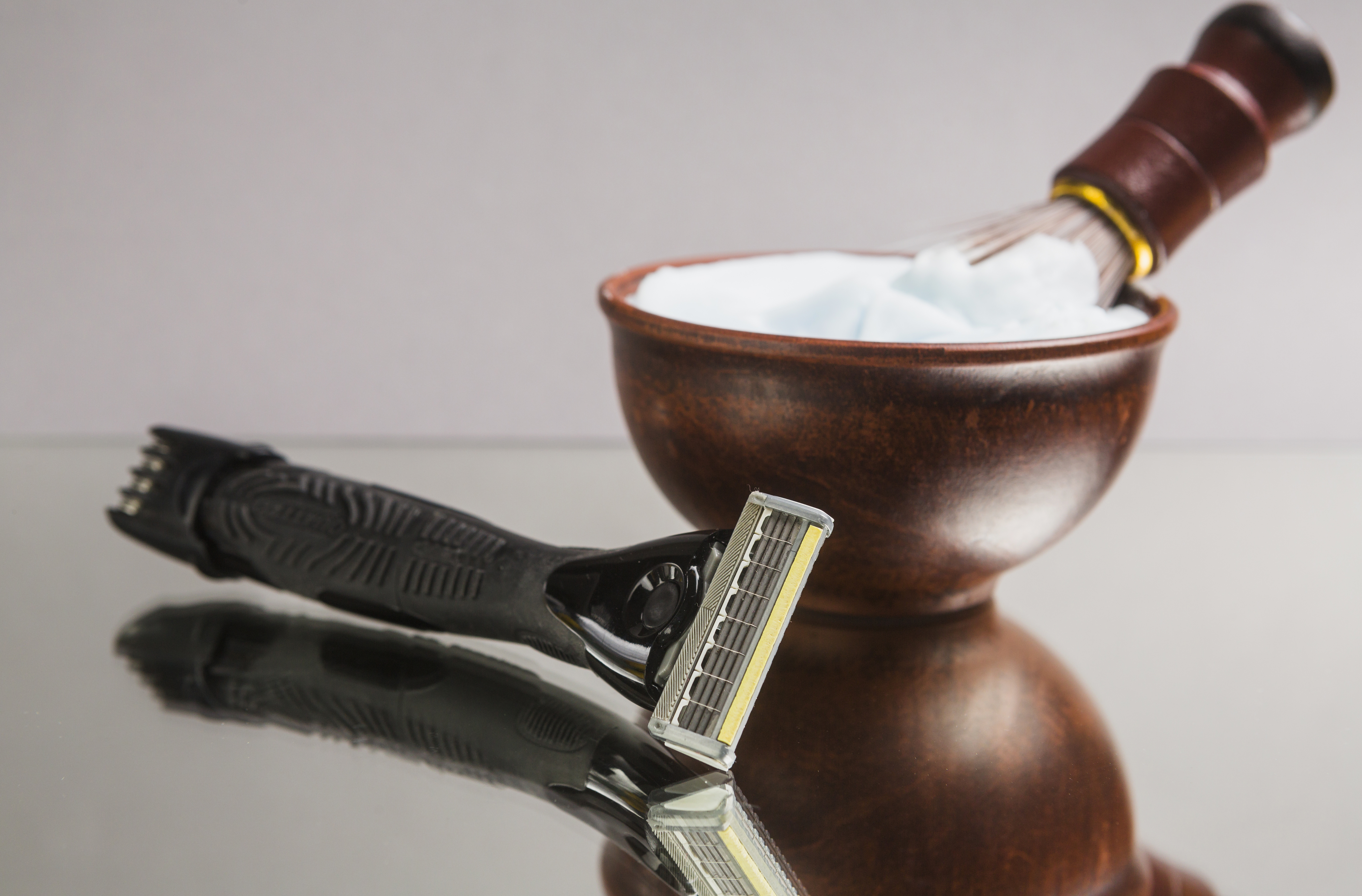 Client enjoying a hot towel straight-razor shave in a barbershop setting.
