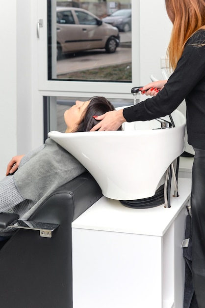 Client reclined at wash station receiving shampoo and scalp massage.