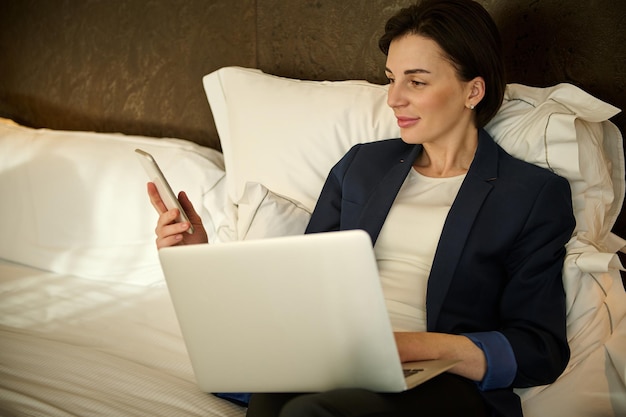 Guest using free Wi-Fi on laptop in comfortable hotel suite.