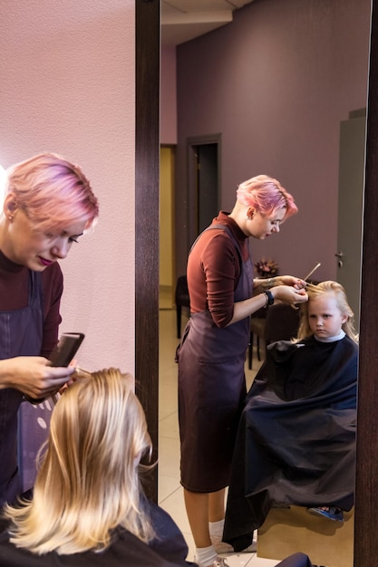 Stylist painting balayage highlights onto a client's hair strands.