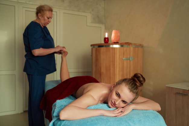 Therapist applying long, gliding strokes during Swedish massage in a comfortable home room.