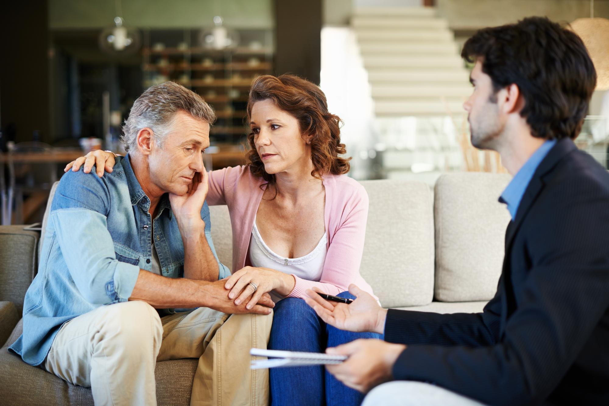 Lawyer speaking empathetically with clients during family law consultation.