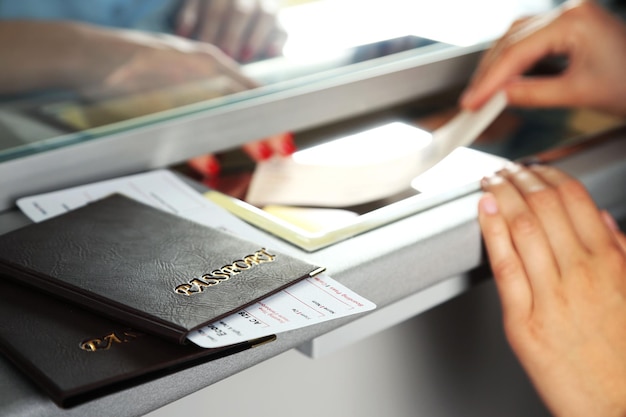 Person handling passport and visa paperwork at an international airport desk.
