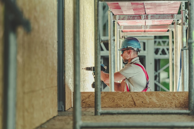 Construction workers building rough framework in an empty apartment space.
