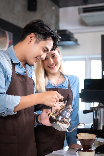 Baristas preparando cafés en el mostrador de VEIA Café & Clubhouse con ambiente profesional y acogedor.