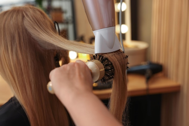Stylist applying seamless hair extensions to a client's natural hair.
