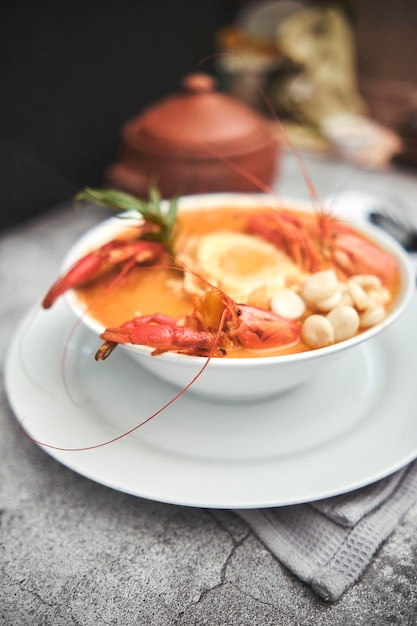 Steaming bowl of lobster bisque with herb garnish.