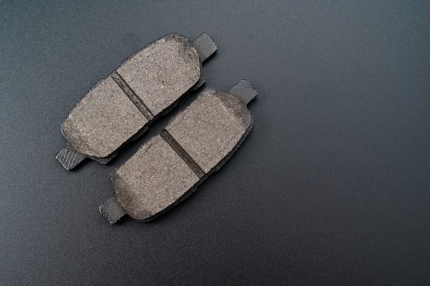 Mechanic repairing brakes on a car, showing new pads installed.