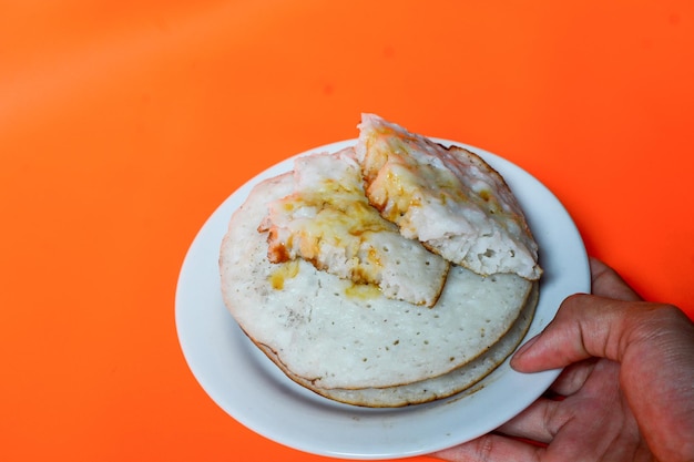 Freshly grilled pupusas with colorful toppings on a serving plate.