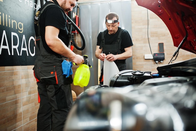 Equipo profesional mostrando productos premium de limpieza para coches en un taller moderno.
