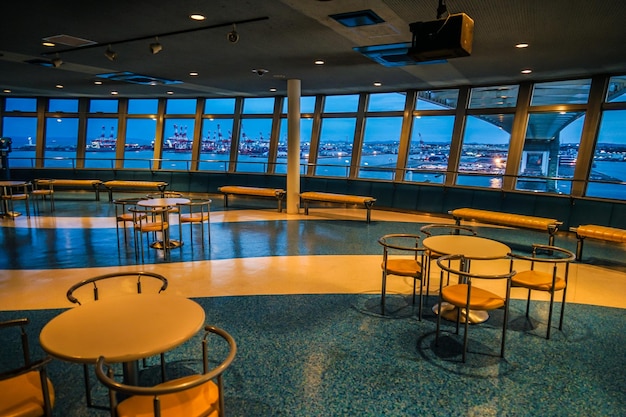 Interior view of a clean, open cruise terminal lobby with counters and signage.