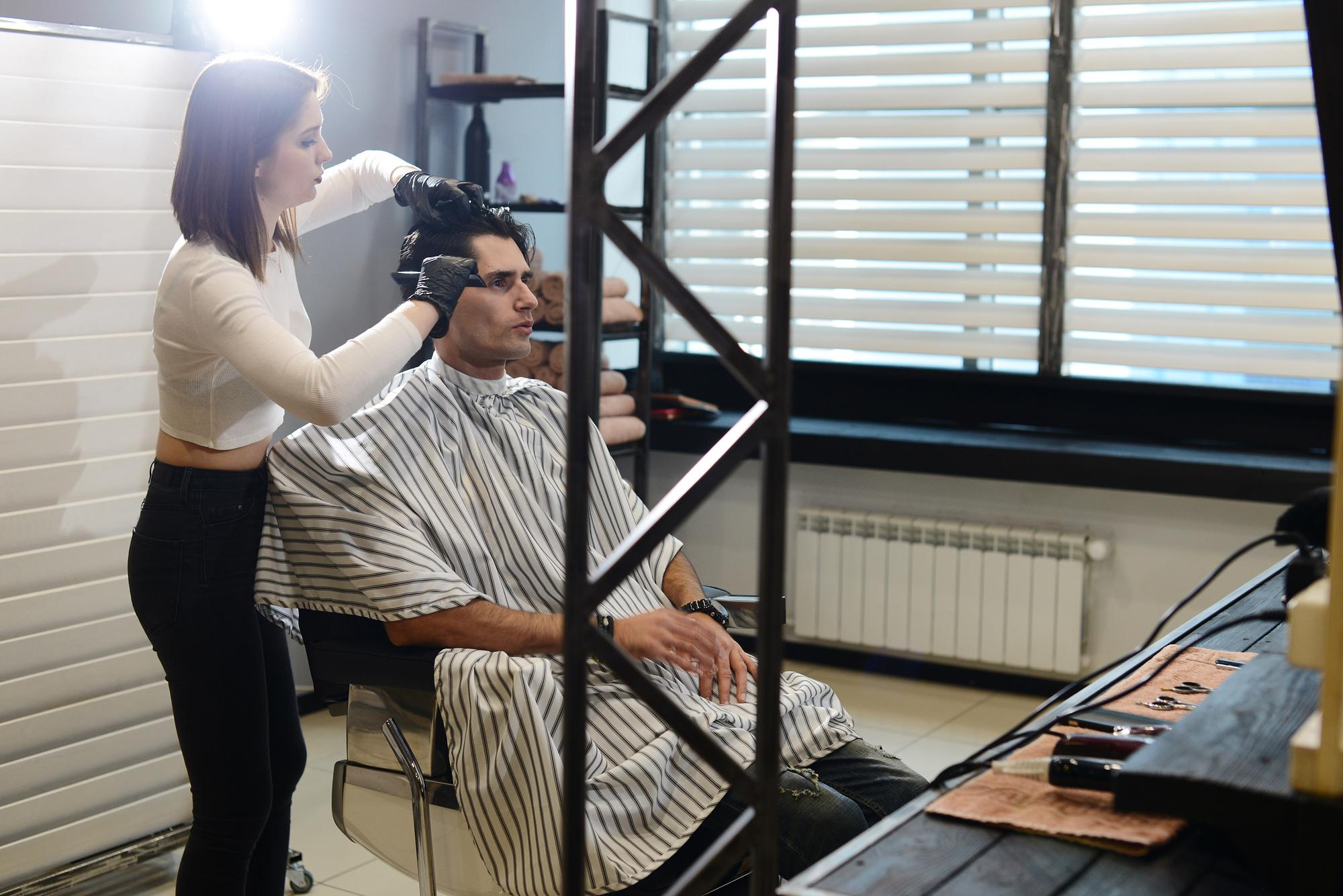 Barber and client discussing hair styling products and techniques.