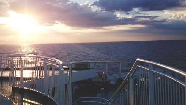 Elegant cruise ship gliding through ocean waters with passengers on sunny decks.