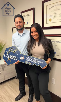 Happy client holding a 'Just Closed' key at the office